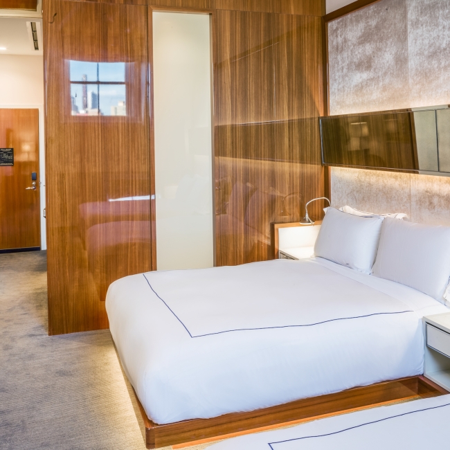 room with two queen beds and wooden accent wall