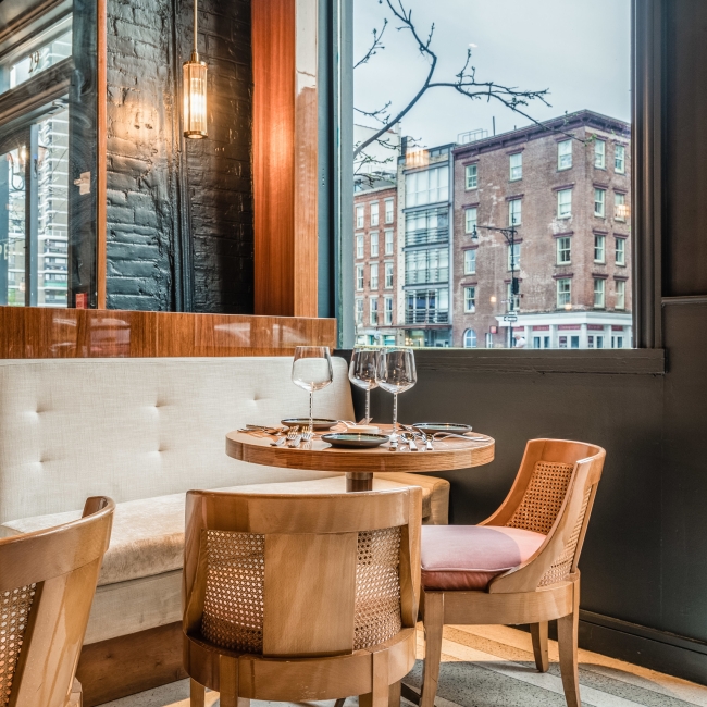 corner table with brown chairs and wine glasses
