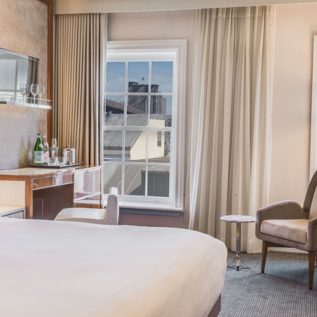 room with king sized bed with views of the brooklyn bridge
