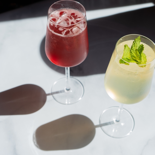 two cocktails in tall wine glasses