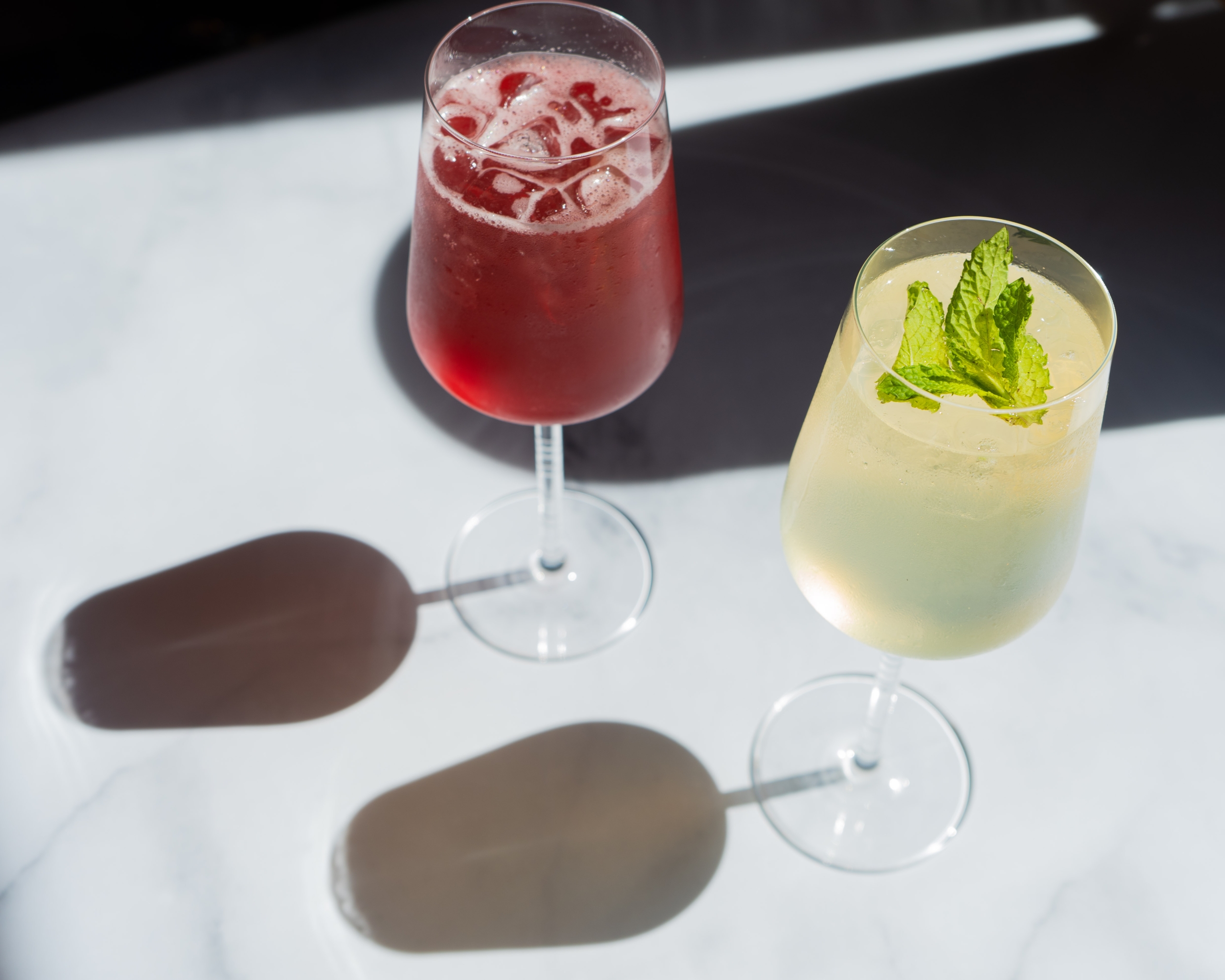 two cocktails in tall wine glasses