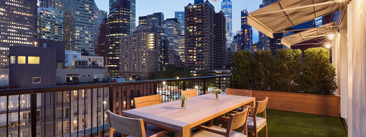outdoor terrace at night with large buildings in the background