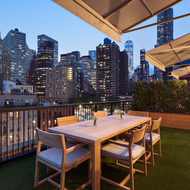 outdoor terrace at night with large buildings in the background