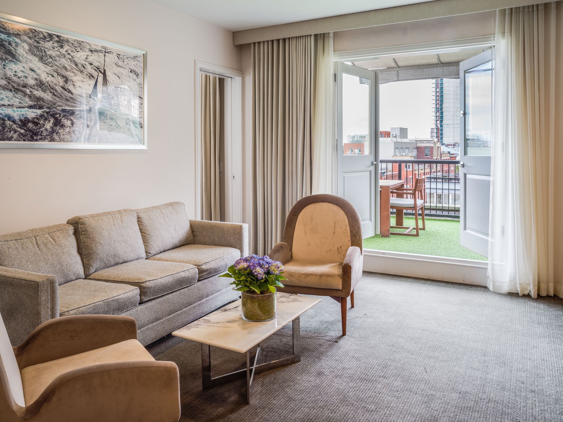 living area with couch and two chairs leading out to a private terrace